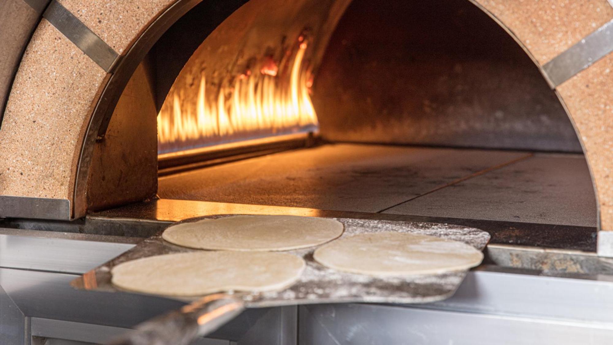 The Abdali Boulevard Hotel Amman Luaran gambar Pizza dough in a wood-fired oven
